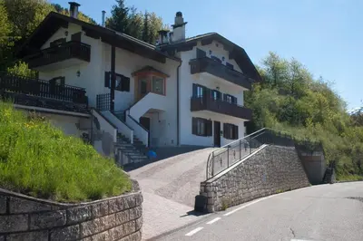a house on a hill with a staircase leading to it at Casa Dolci by Sunhome Fiemme in Tesero