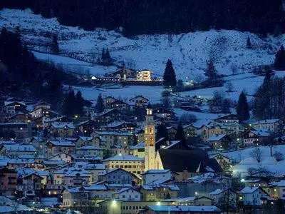 a city lit up at night in the snow at Casa Dolci by Sunhome Fiemme in Tesero