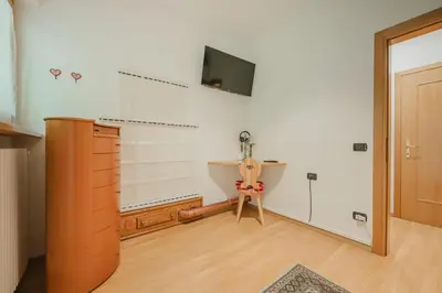 a bathroom with a sink and a tv on the wall at I Folli di Alleghe Apartment - Parking & Wi-Fi in Caprile