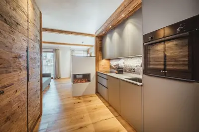 a kitchen with a stove and a fireplace at Kuenzerhof Apartments in Braies