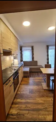 a kitchen and living room with a couch and a table at Wohnung in Olang, perfekte Unterkunft für Olympia in Valdaora di Sotto