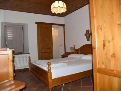 a bedroom with two beds and a chandelier at Casa Via Soia in Canale dʼAgordo