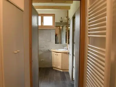 a small bathroom with a sink and a mirror at Casa Via Soia in Canale dʼAgordo