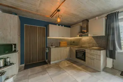 a kitchen with white cabinets and blue walls at Cozy Apartment At The Foot Of The Dolomites in Campitello di Fassa