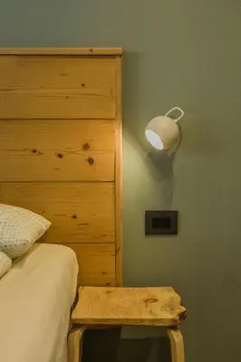 a bedroom with a bed and a dresser with a lamp at Cozy Apartment At The Foot Of The Dolomites in Campitello di Fassa