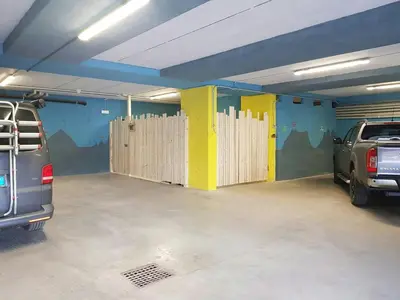 a garage with wooden doors in a parking lot at Cozy Apartment At The Foot Of The Dolomites in Campitello di Fassa