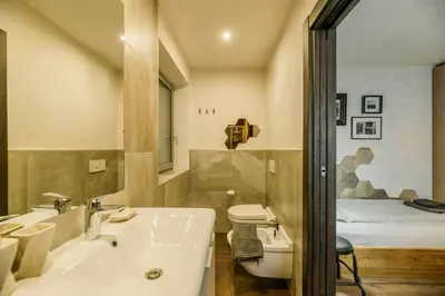 a bathroom with a sink and a toilet and a bed at Family-Friendly Mountain Home In The Dolomites in Campitello di Fassa