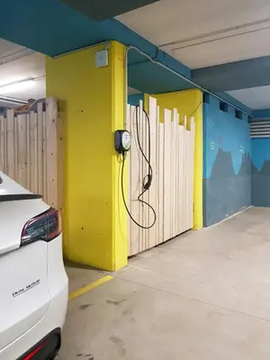 a parking garage with a yellow wall with a hose at Family-Friendly Mountain Home In The Dolomites in Campitello di Fassa