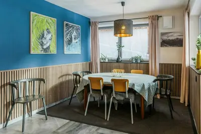 a dining room with blue walls and a table and chairs at Family-Friendly Mountain Home In The Dolomites in Campitello di Fassa