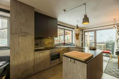 a kitchen with wooden cabinets and a counter top at Apartment In The Dolomites With Panoramic View in Campitello di Fassa
