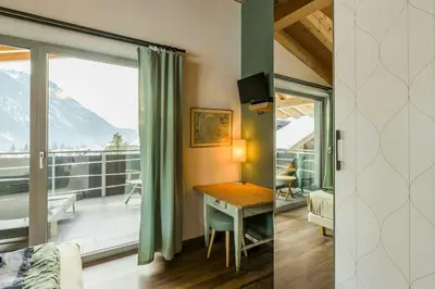 a room with a desk and a balcony with a view at Apartment In The Dolomites With Panoramic View in Campitello di Fassa