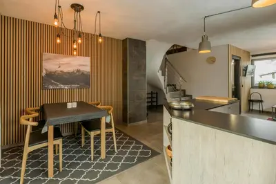 a kitchen with a table and a dining room at Apartment In The Dolomites With Panoramic View in Campitello di Fassa