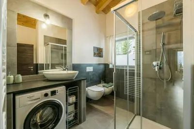 a bathroom with a washing machine and a sink at Apartment In The Dolomites With Panoramic View in Campitello di Fassa