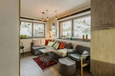 a living room with a couch and a table at Apartment In The Dolomites With Panoramic View in Campitello di Fassa
