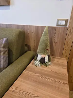 a small gnome sitting on a table next to a couch at Appartamento La Meridiana in Tonadico