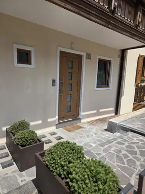 a building with a door and some plants in a courtyard at Appartamento La Meridiana in Tonadico