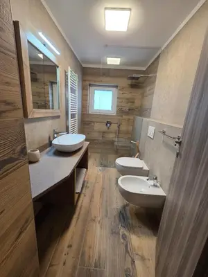 a bathroom with two sinks and two toilets at Appartamento La Meridiana in Tonadico