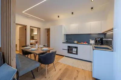 a kitchen and living room with a table and chairs at Appartament Seceda in San Sigismondo