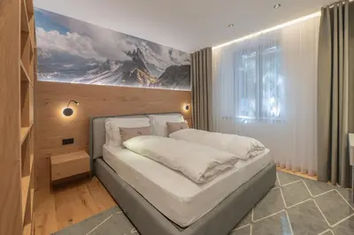 a bedroom with a bed with a painting on the wall at Appartament Seceda in San Sigismondo