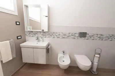 a bathroom with a sink and a toilet and a mirror at La bottega del sarto in Grumes