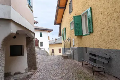 a bench sitting on a street next to a building at La bottega del sarto in Grumes