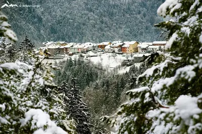 a small town in the snow on a mountain at La bottega del sarto in Grumes