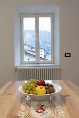 a bowl of fruit on a table with a window at La bottega del sarto in Grumes