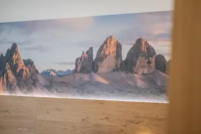 a bedroom with a bed with a painting on the wall at Apartament Tre Cime in San Sigismondo