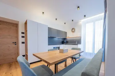 a kitchen with a wooden table and chairs at Appartament Lago di Braies in San Sigismondo