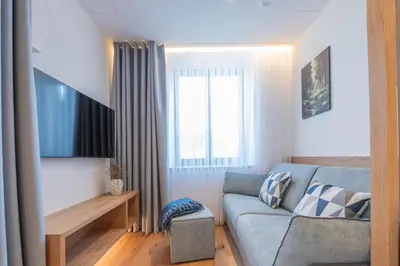 a living room with a flat screen tv on a wall at Appartament Lago di Braies in San Sigismondo