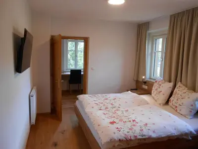 a bedroom with a large bed in a room with windows at Ferienwohnung Lamprechtsburg in Brunico