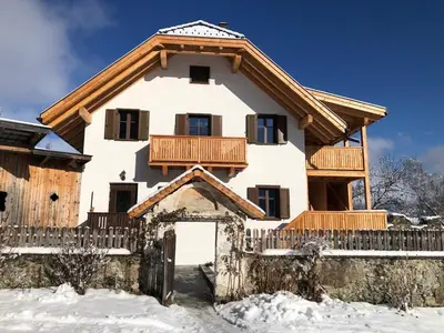 a house in the snow with a balcony at Ferienwohnung Lamprechtsburg in Brunico