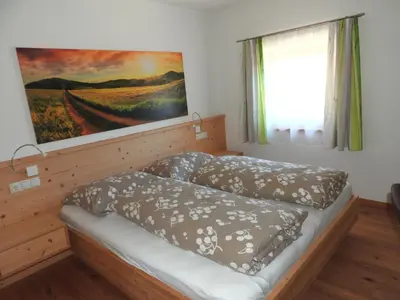 a bedroom with a bed and a painting on the wall at Hanslmoar Hof in Colli in Pusteria