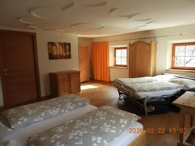 a bedroom with two beds and a wooden floor at Hanslmoar Hof in Colli in Pusteria