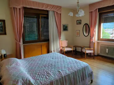 a bedroom with a bed and a table and chairs at La Casa di Anna in Agordo