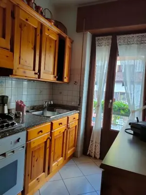 a kitchen with wooden cabinets and a sink and a window at La Casa di Anna in Agordo