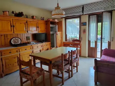 a kitchen with a wooden table and chairs in a room at La Casa di Anna in Agordo