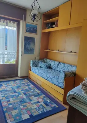 a bedroom with a bed and a rug at La Casa di Anna in Agordo