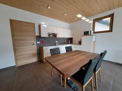 a kitchen with a wooden table and chairs at Apartment Sonnschein Brunnerhof in Feldthurns