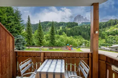 a table and chairs on a balcony with a view at Paola in Santa Cristina in Val Gardena