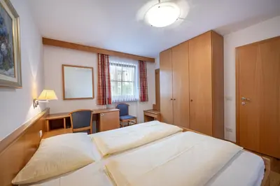 a bedroom with a bed and a desk and a chair at Paola in Santa Cristina in Val Gardena