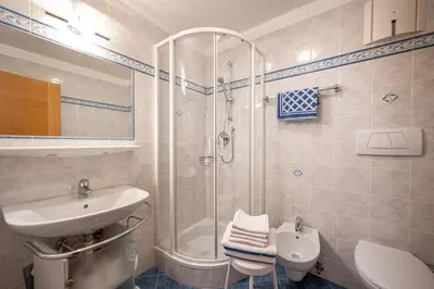 a bathroom with a shower and a sink and a toilet at Paola in Santa Cristina in Val Gardena
