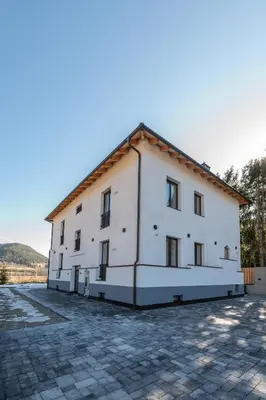a white house with a snow covered driveway at Plan de Corones Apartment in San Sigismondo