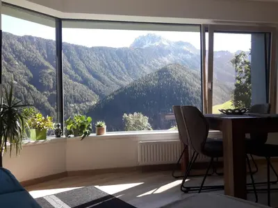 a room with a table and a view of mountains at Hofstatthof in Campo di Trens