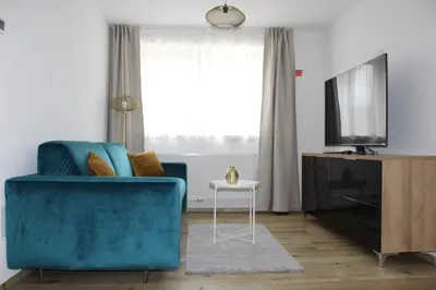 a living room with a blue couch and a television at Fox Appartements in San Lorenzo di Sebato