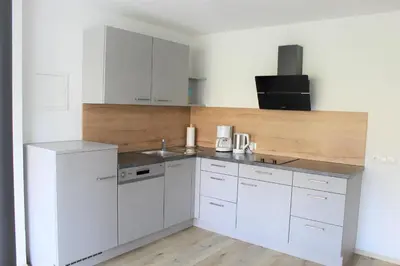 a white kitchen with white cabinets and a sink at Fox Appartements in San Lorenzo di Sebato