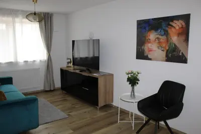 a living room with a tv and a blue couch at Fox Appartements in San Lorenzo di Sebato