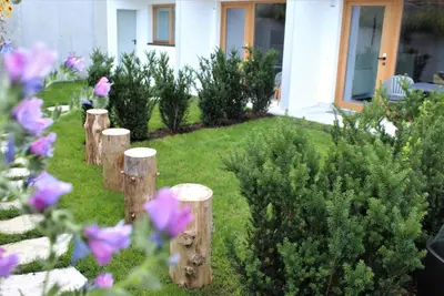 a garden with wooden posts and purple flowers at Fox Appartements in San Lorenzo di Sebato