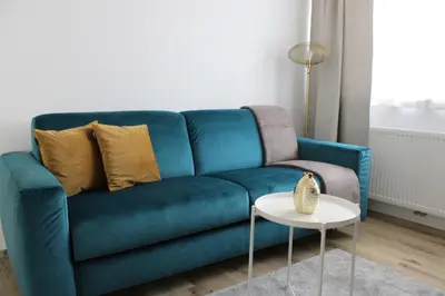 a blue couch in a living room with a table at Fox Appartements in San Lorenzo di Sebato