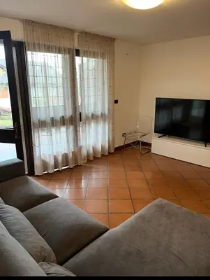 a living room with a couch and a flat screen tv at Villa Claudio in Cavareno